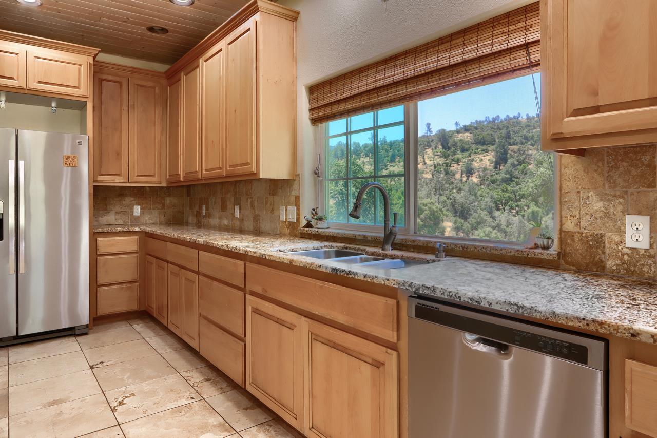 7551 Hunters Valley Road Mariposa, CA 95338 - Photo 26 of 78 a kitchen with granite countertop a sink and a refrigerator