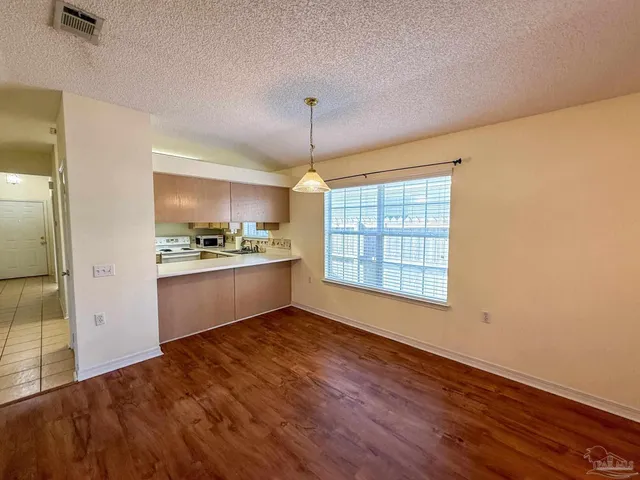 a kitchen with granite countertop wooden floors and white appliances