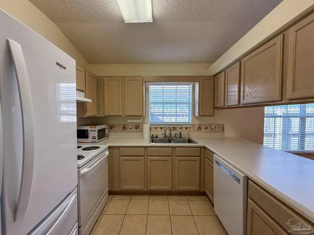 a kitchen with a sink a stove a refrigerator and cabinets