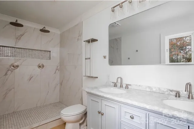 a bathroom with a granite countertop sink a toilet and a mirror