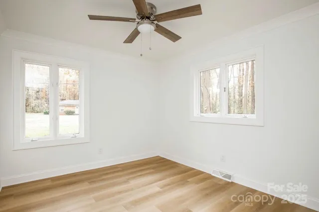 a view of empty room with window and a ceiling fan