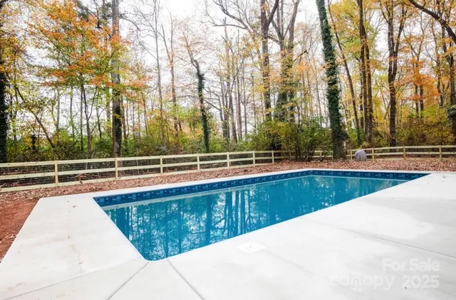 a view of a swimming pool with trees in the background