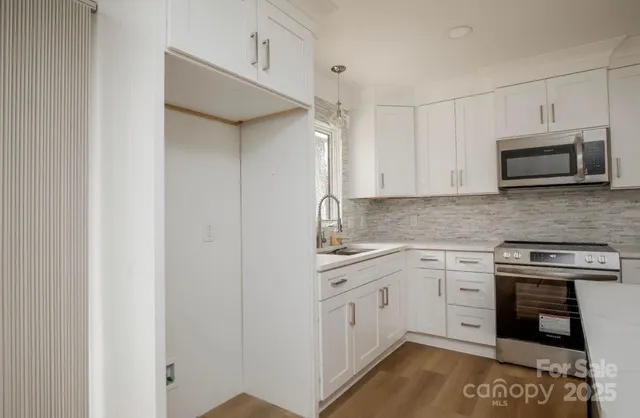 a kitchen with stainless steel appliances granite countertop a stove and a microwave