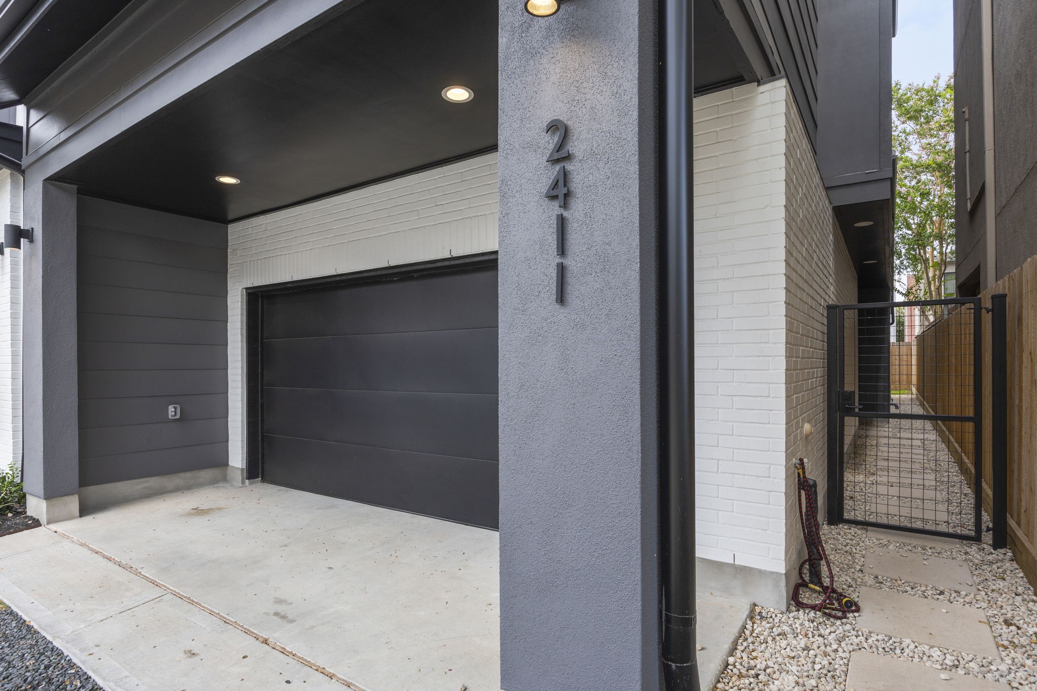 2411 Hazard Street Houston, TX 77019 - Photo 6 of 46 The private side walkway, lined with modern pavers and sleek fencing, provides a discreet and stylish path leading to the front entrance. This gated side access adds convenience while enhancing the home's overall privacy and security.