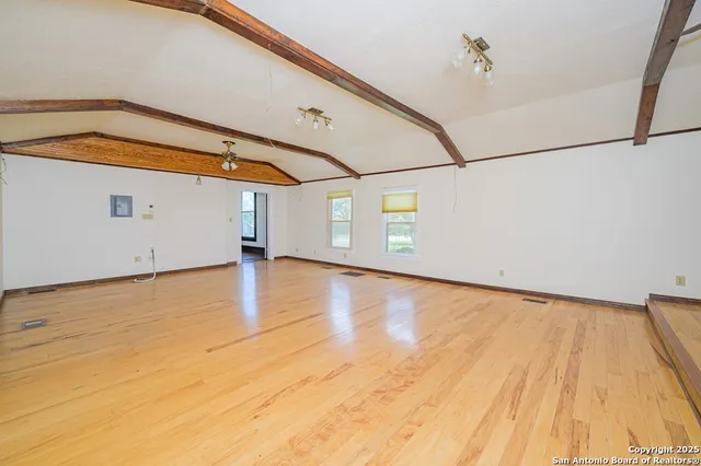 an empty room with windows and fan