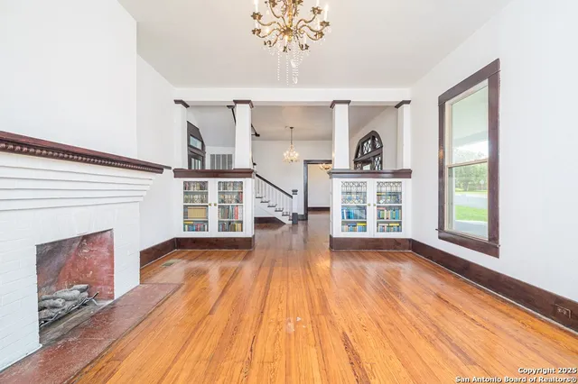 a view of empty room with wooden floor and fireplace