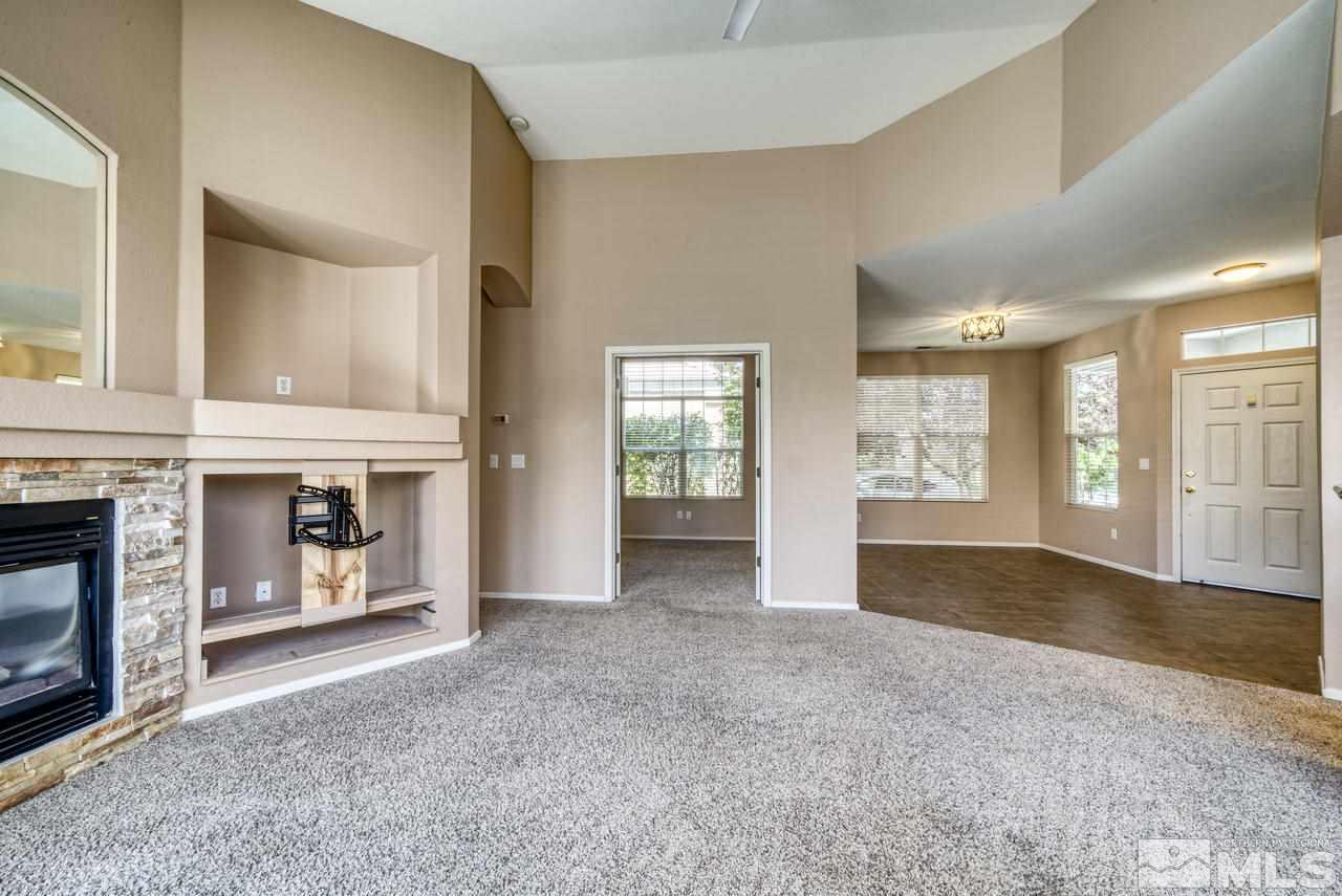 9683 Truckee Meadows Place Reno, NV 89521 - Photo 18 of 33 a view of an empty room with a fireplace and a window