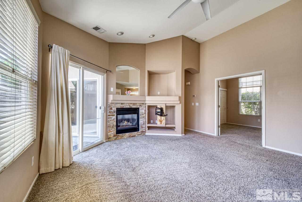 9683 Truckee Meadows Place Reno, NV 89521 - Photo 4 of 33 an empty room with furniture and a fireplace