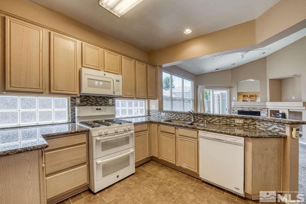 9683 Truckee Meadows Place Reno, NV 89521 - Photo 6 of 33 a kitchen with stainless steel appliances granite countertop a stove sink and cabinets