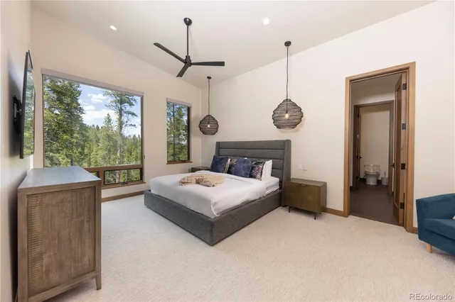 a bedroom with a large bed and a chandelier