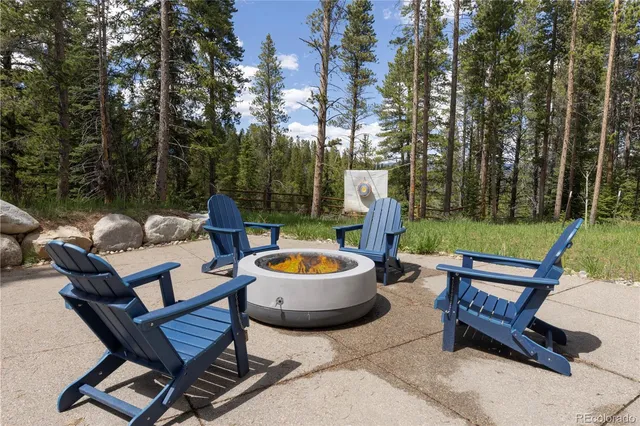 a backyard of a house with fire pit and outdoor seating
