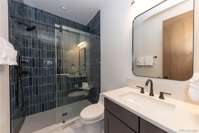 a bathroom with a sink toilet vanity and shower