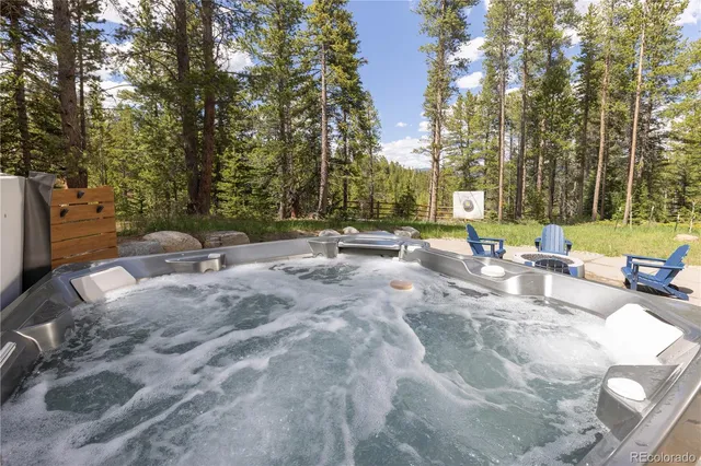 a view of backyard with swimming pool and seating space