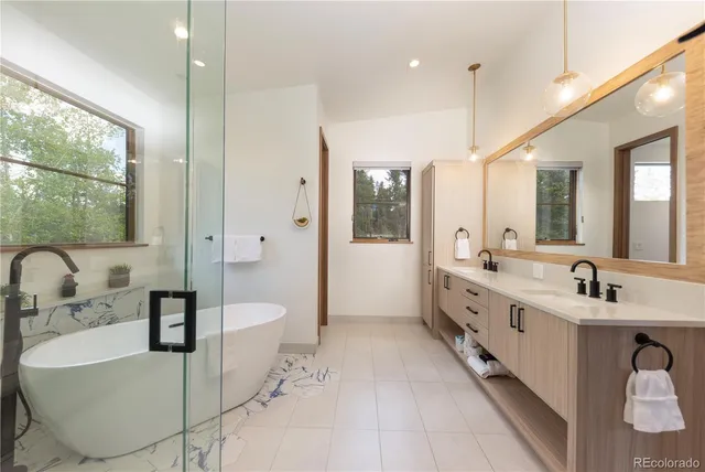 a large bathroom with a double vanity sink a mirror and a bathtub
