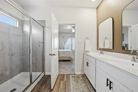 a bathroom with a double vanity sink and mirror with shower