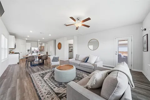 a living room with furniture a rug and a ceiling fan
