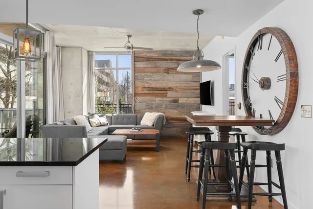 a living room with furniture a large window and a chandelier