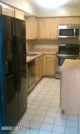 a kitchen with a refrigerator sink and cabinets