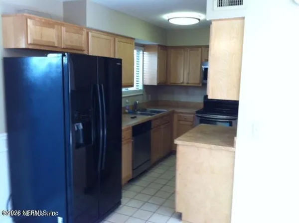 a kitchen with a refrigerator and a sink