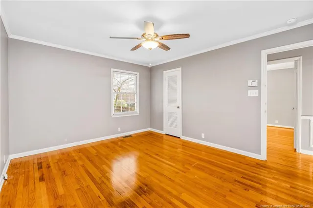 a view of a big room with wooden floor and a ceiling fan