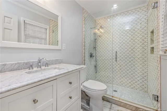 a bathroom with a granite countertop sink a toilet and shower