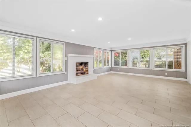 a view of an empty room with a window and a fireplace