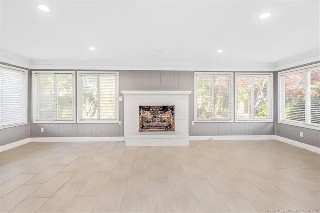 an empty room with windows and a fireplace