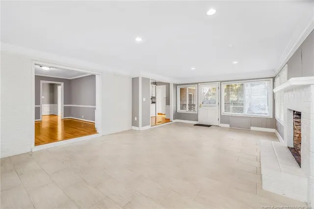 a view of an empty room with a fireplace and a window