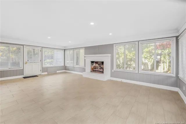 an empty room with fireplace and windows