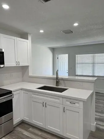 a kitchen with granite countertop white cabinets and white appliances