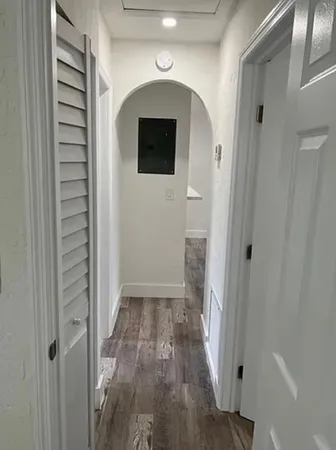 a view of a hallway with wooden floor and staircase