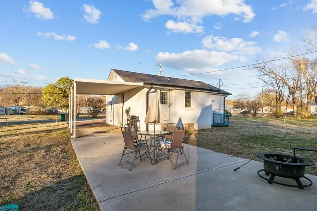 a view of a patio with table and chairs with wooden floor and fence