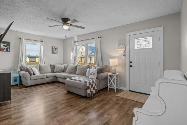a living room with furniture and a wooden floor