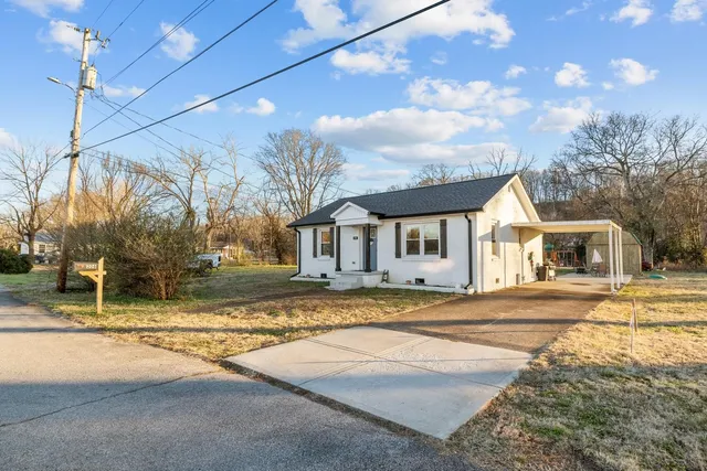 a view of a house with a patio and a yard