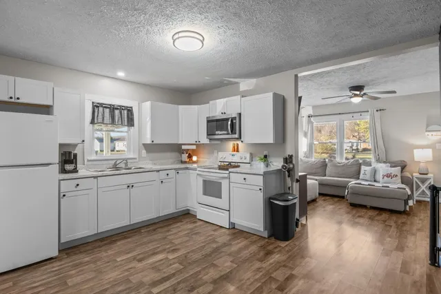 a kitchen with granite countertop a sink cabinets and wooden floor