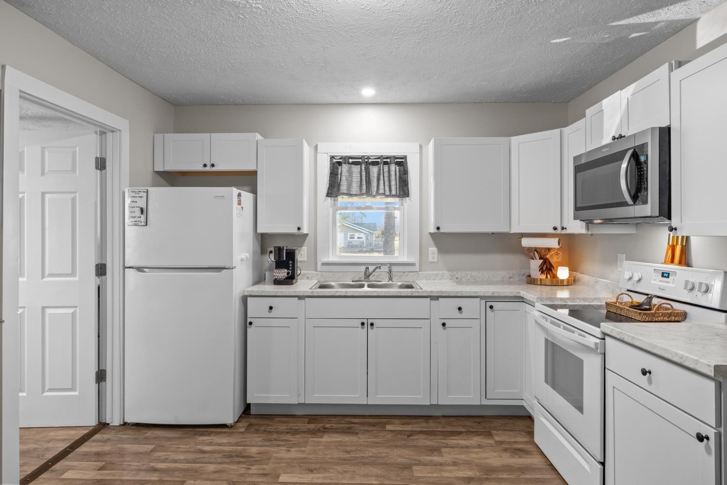 206 Joe Street Waverly, TN 37185 - Photo 7 of 28 a kitchen with granite countertop a refrigerator stove microwave and sink