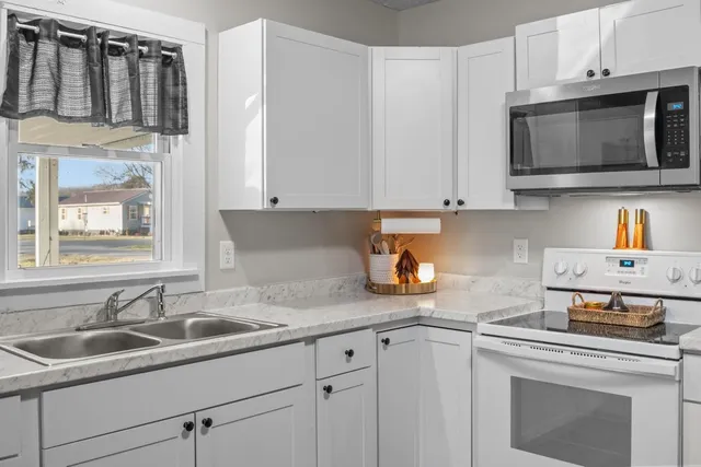 a kitchen with stainless steel appliances granite countertop a sink a stove and microwave