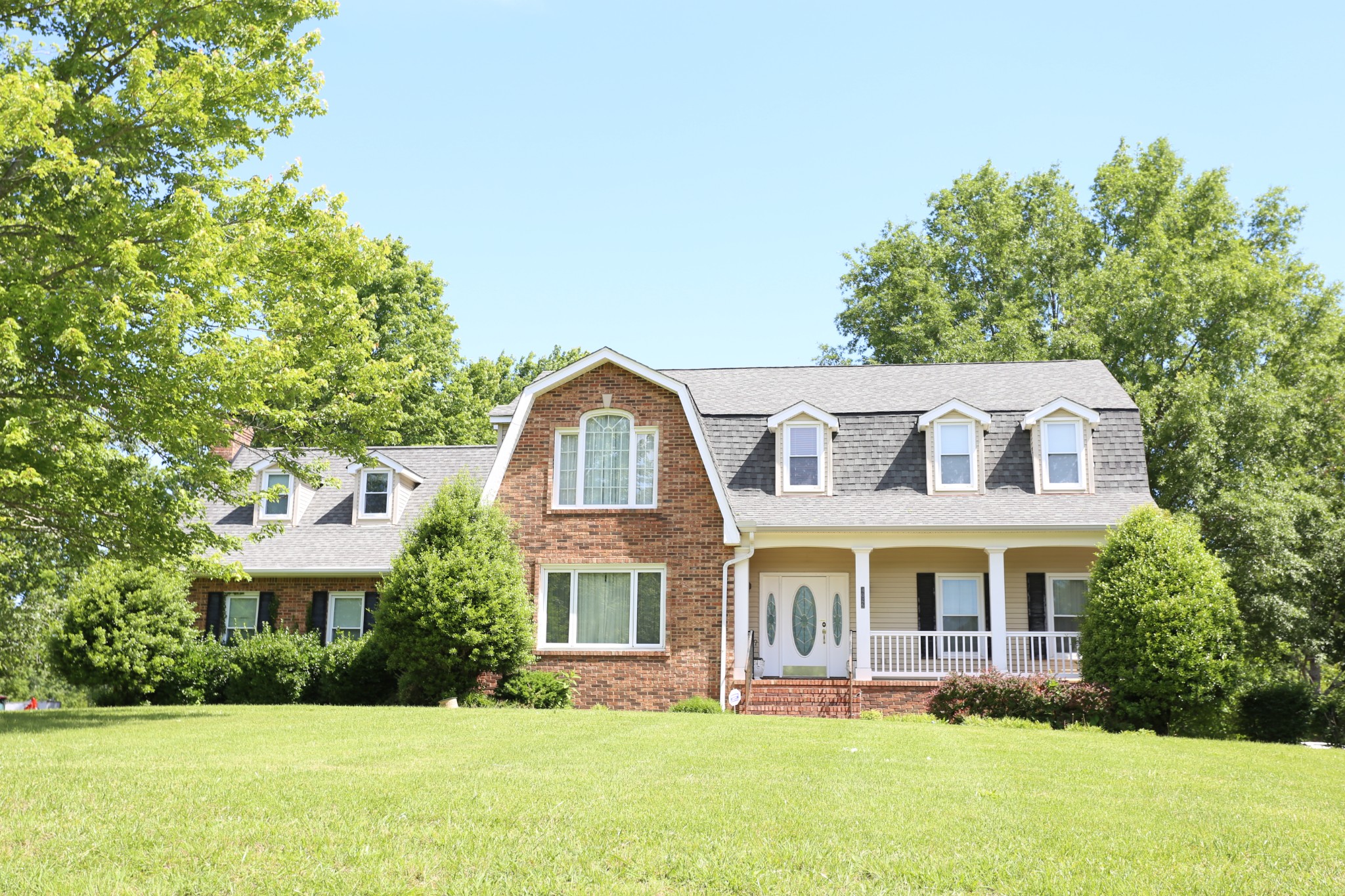 a front view of a residential houses with yard and green space