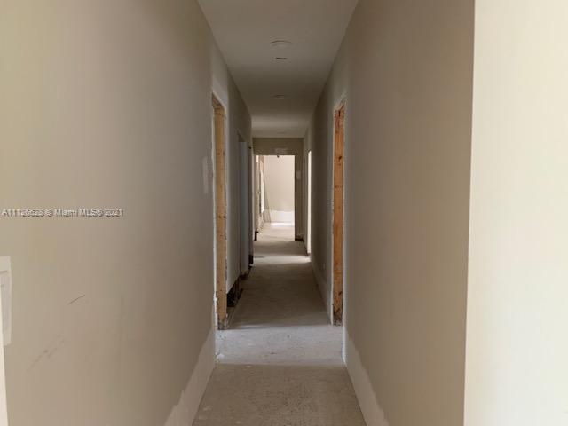 323 Caribbean Road Key Biscayne, FL 33149 - Photo 17 of 20 a view of a hallway with wooden shelves