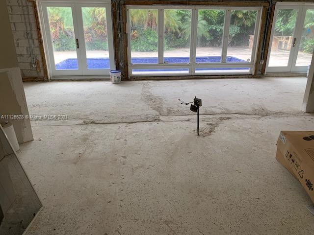 323 Caribbean Road Key Biscayne, FL 33149 - Photo 18 of 20 a living room with a floor to ceiling window and a fireplace