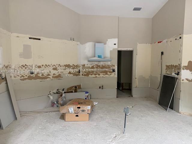 323 Caribbean Road Key Biscayne, FL 33149 - Photo 9 of 20 a room with water heater and wooden cabinets