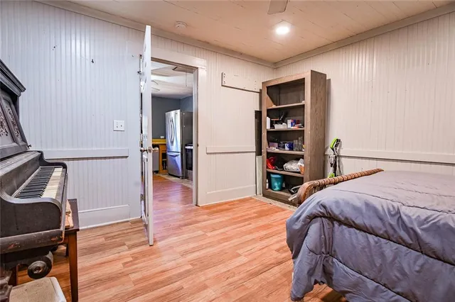 a bedroom with wooden floor and a closet