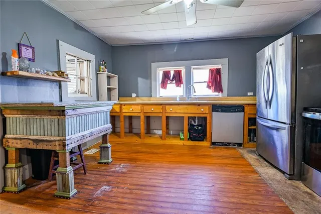 a living room with stainless steel appliances kitchen island granite countertop furniture and a fireplace