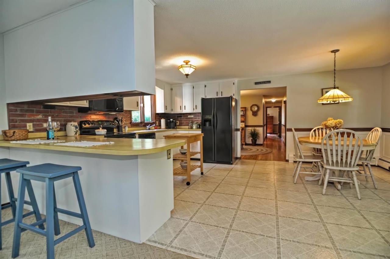 222 Prince Hinckley Road Centerville, MA 02632 - Photo 8 of 31 a kitchen with refrigerator cabinets dining table and chairs