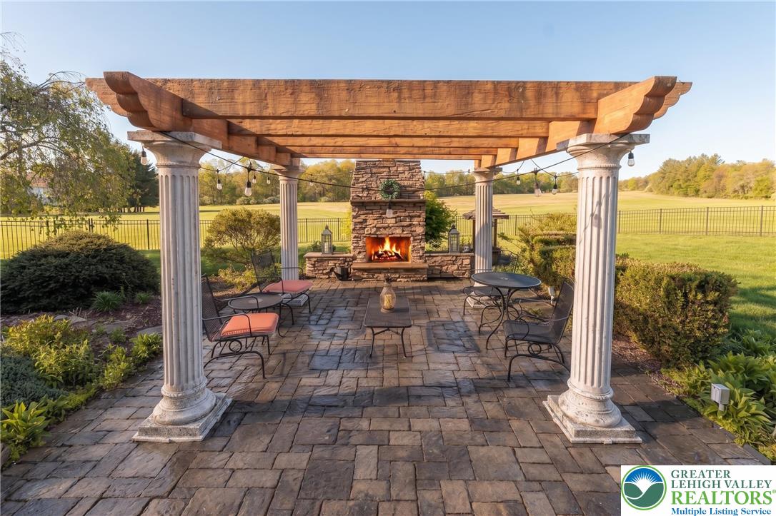 1089 Deemer Road Bath, PA 18014 - Photo 10 of 57 This inviting outdoor living space features a stone fireplace and elegant pergola, perfect for gatherings.