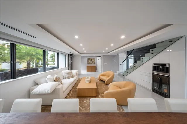 a living room with furniture a flat screen tv and a large window
