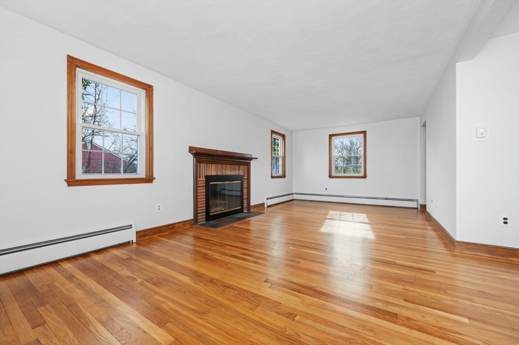 15 Shawmut Road Waltham, MA 02452 - Photo 11 of 40 a view of empty room with wooden floor and fireplace