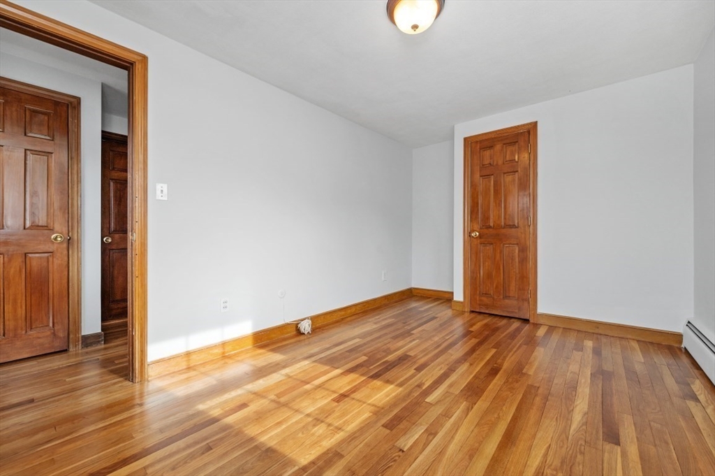 15 Shawmut Road Waltham, MA 02452 - Photo 20 of 40 an empty room with wooden floor and windows