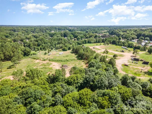 an aerial view of a houses with a lush green hillside