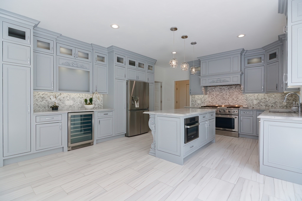 23 Newell Drive Franklin, MA 02038 - Photo 11 of 35 a kitchen with refrigerator a stove and white cabinets